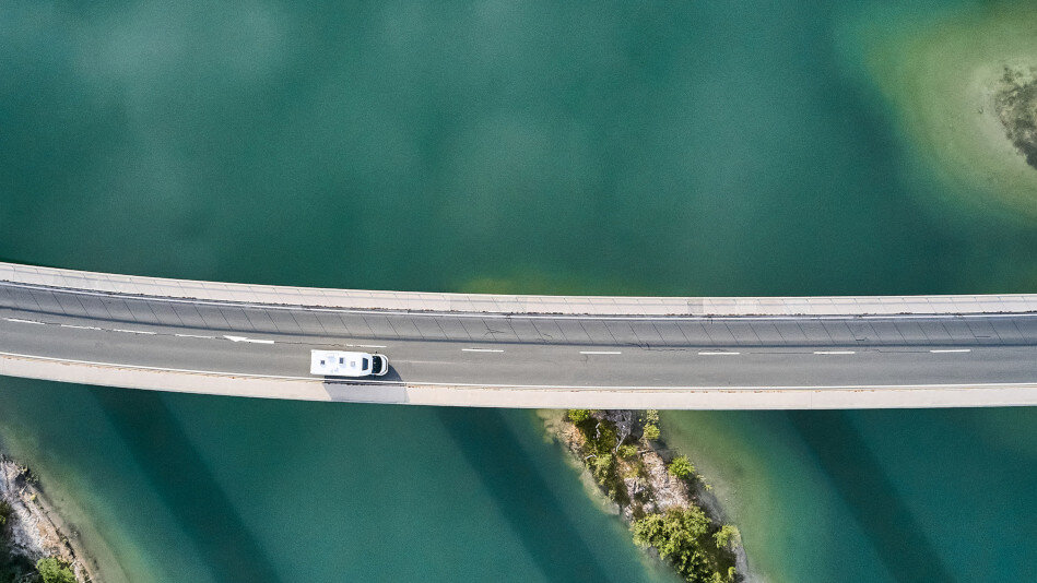 Wohnmobil auf Brücke über Fluss, Vogelperspektive