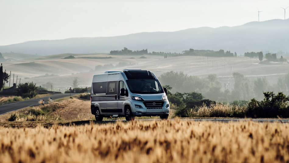 Wohnmobil auf Landstraße durch Kornfelder